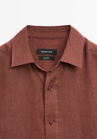 Brown linen shirt with a button-down collar, featuring two brown buttons and a label reading "Massimo Dutti" in black.
