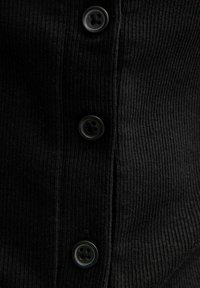 Czarna prążkowana tkanina z pięcioma czarnymi guzikami ułożonymi pionowo, ukazująca teksturowaną powierzchnię i delikatne cienie.