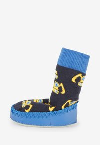 Texturerad blå bas med en mörk socka som har gula och blå mönster. Rundad tå med dekorativ söm längs kanten.