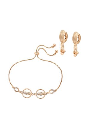 Bracciale regolabile color oro con design a foglia e cristalli trasparenti, abbinato a orecchini a cerchio color oro con grappoli di perle pendenti.