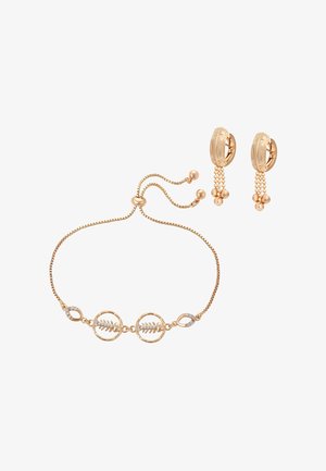 Bransoletka w złotym odcieniu z regulacją, zdobiona liściastym wzorem i przezroczystymi kryształami, w komplecie z kolczykami kołami w złotym odcieniu z wiszącymi klastrami koralików.
