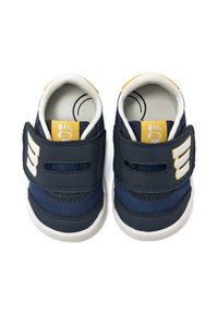 Zapatos infantiles azul marino con acentos blancos, correas de velcro, parte superior de tela suave y suela de goma. Presentan un logotipo en el lateral.