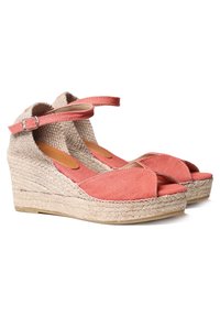 Sandali con zeppa in tela corallo, sole in juta intrecciata e cinturino alla caviglia. Design open-toe con fasce incrociate e dettagli in tessuto testurizzato.
