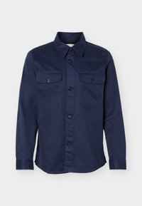 Μπλε σκούρο πουκάμισο με μακριά μανίκια, κουμπιά στο εμπρός μέρος και δύο τσεπάκια στο στήθος με κουμπιά, εμφανίζεται σε λευκό φόντο.