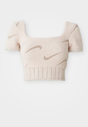 Top court à manches courtes en tissu doux et texturé. Couleur rose clair avec des motifs ondulés marron. Décolleté carré et ourlet côtelé.