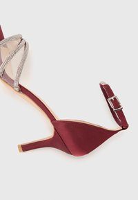 Bordeaux satiini stilettokengät, joissa on verkko- ja timanttikoristeet, kärkiosa on terävä, ja säädettävä nilkkaremmi hopeasoljella.