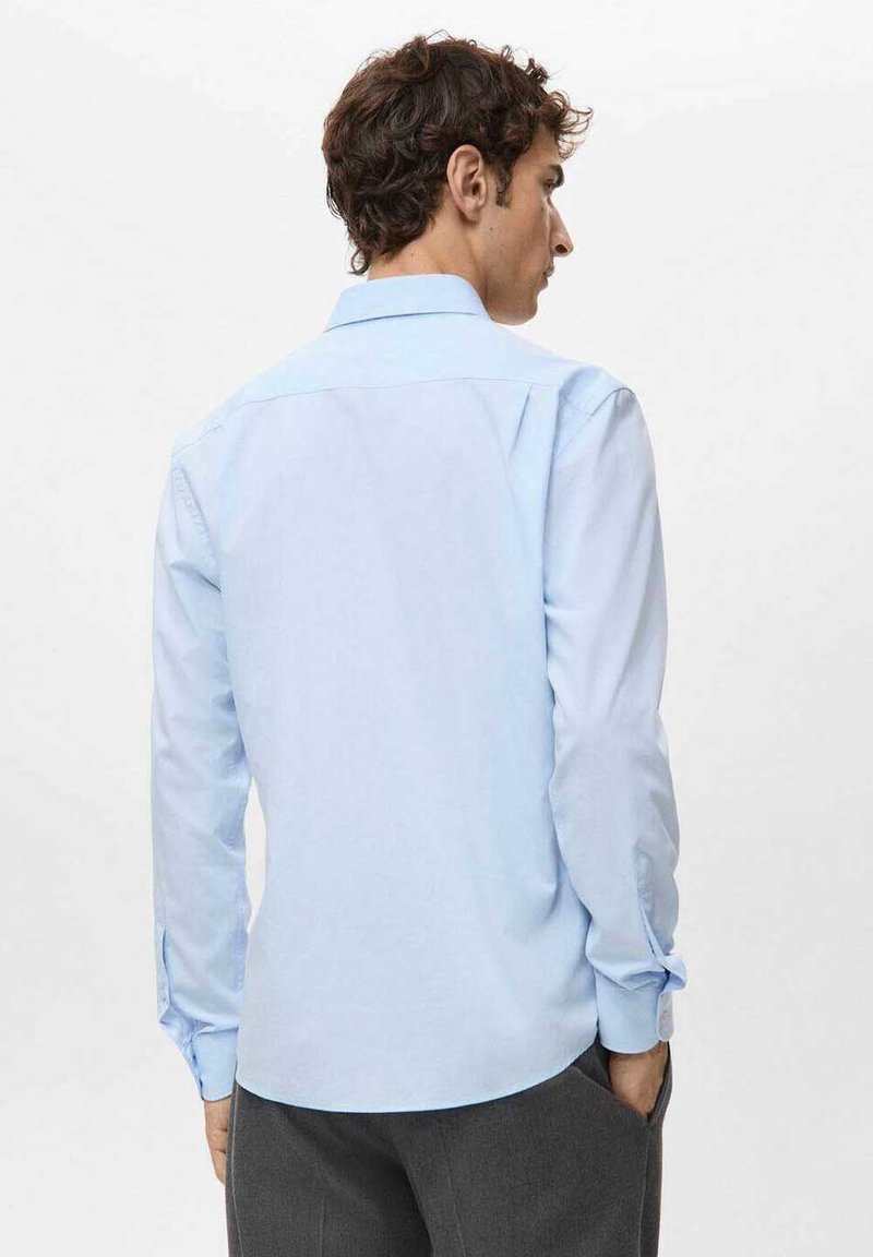 Camicia a maniche lunghe azzurro chiaro in tessuto liscio con colletto classico, caratterizzata da bottoni sui polsini e un design posteriore pulito.