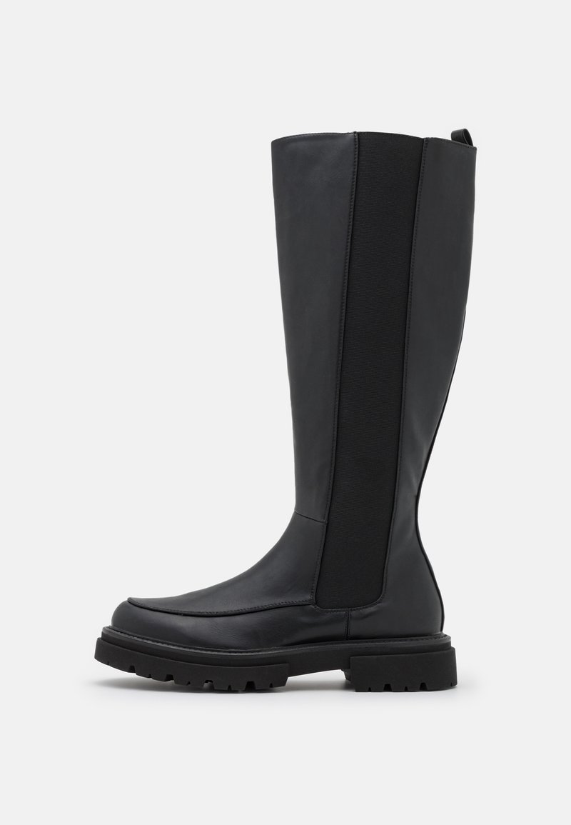 Bota negra hasta la rodilla con cuero liso y paneles laterales elásticos, punta cuadrada, suela gruesa y tirador en la parte posterior.
