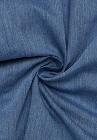 Denim stof i en mellemblå nuance, med en glat tekstur og et subtilt twill mønster, samlet i en spiralform.