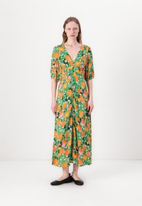 Florales Maxikleid in Grün mit orangefarbenen und rosa Blumen. Hat einen tiefen V-Ausschnitt, Puffärmel und Knopfdetails an der Vorderseite.
