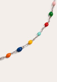 Collar de cadena de cuentas coloridas con cuentas de cerámica ovaladas y brillantes en rojo, verde, rosa, azul, amarillo, naranja y turquesa, sobre una cadena de metal plateado.