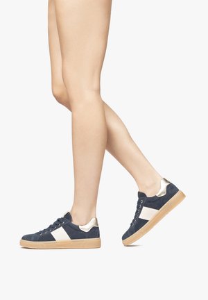 Sneakers in camoscio blu con strisce bianche sui lati e dettagli dorati. Suola in gomma piatta e design a punta rotonda, con occhielli metallici per i lacci.