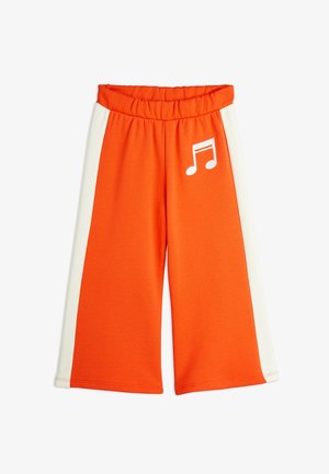 Pantalones de pierna ancha de algodón naranja brillante con un panel lateral blanco y un detalle bordado de nota musical en la parte frontal. Cintura elástica.