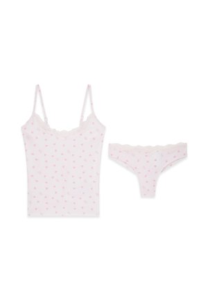 Weißes Damen-Camisole und passender String mit pinkfarbenen Herzmustern und Spitzenbesatz auf weißem Hintergrund.
