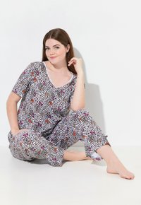 Pajama-Set aus weicher Baumwolle mit einem weißen Hintergrund und einem bunten Tierdruck. Kurzärmliges Oberteil und Hose mit einer lässigen Passform.