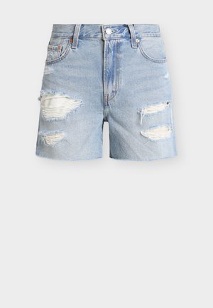 Shorts en denim bleu clair avec bords effilochés et plusieurs grandes déchirures laissant apparaître un tissu blanc en dessous.