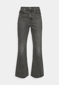 Jeans negros acampanados de talle alto con un acabado de denim desgastado, bolsillos frontales, cierre de botón y corte ancho en el tobillo.