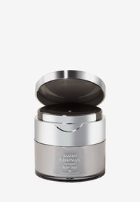 Silberner und grauer Cremetiegel mit metallischem Deckel, elegantem Design, runder Form und geprägt gestaltetem Branding auf der Vorderseite.