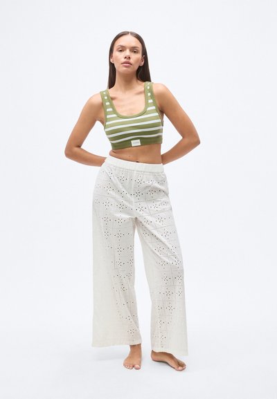 Πράσινο και λευκό ριγέ crop top με φαρδιούς ιμάντες σε συνδυασμό με λευκό, άνετο παντελόνι με σχέδια από ανοίγματα και ελαστική μέση.