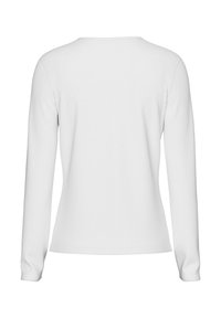 Long-sleeve white top with a round neckline, seamless shoulders, and fitted design. Soft cotton blend with smooth texture and minimal detailing.