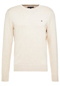 Beżowy sweter z dzianiny z okrągłym dekoltem, długimi rękawami i prążkowanymi mankietami. Na piersi małe logo. Miękka, teksturowana tkanina.