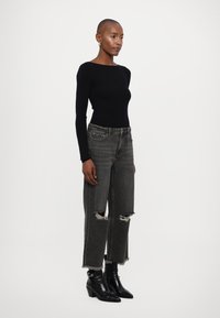 Musthave must valge t-särk, hallid rebenenud teksad ning pahkluu kingad. Kitsas lõige särk, laiad jalad teksad lahtiste äärtega ning läikivad nahkkingad.