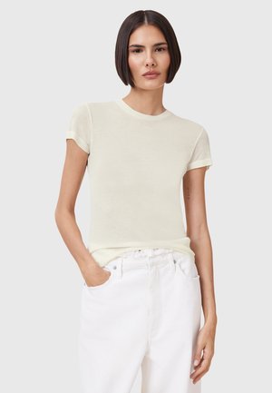 T-shirt fitted giallo chiaro con maniche corte, collo a girocollo rigato e texture liscia, abbinato a pantaloni bianchi a vita alta.