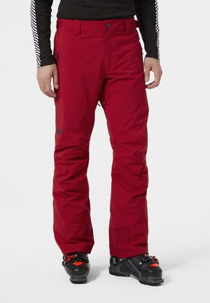 Rode waterdichte skibroek met een gladde textuur, taps toelopende pasvorm, zijzakken met rits en logo-opdruk op de linkerbovenbeen.