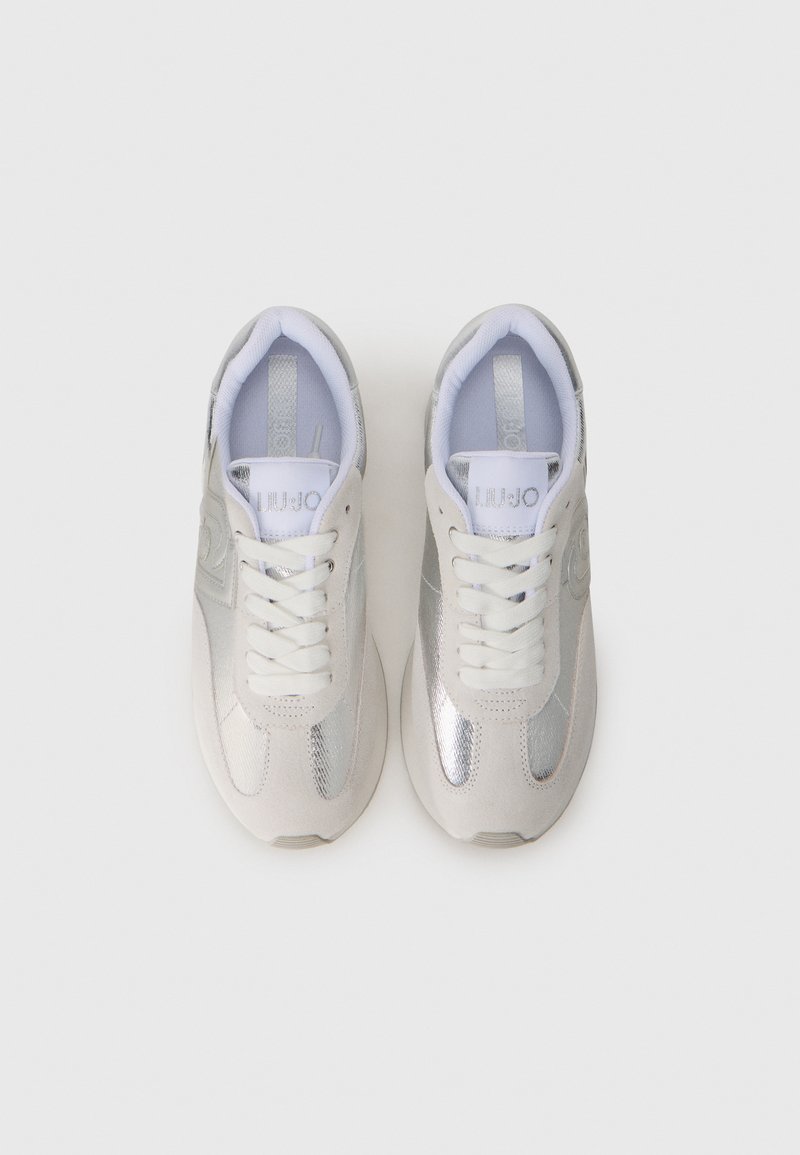 Scarpe da ginnastica argentate con un mix di materiali lisci e texturizzati, dotate di lacci bianchi e dettagli con logo. Punta arrotondata e colletto imbottito.