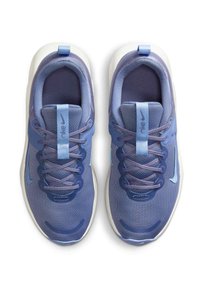 Zapatillas deportivas de color púrpura claro con parte superior de malla, cordones en contraste y suela blanca. Presentan el logo de Nike y una lengüeta en el talón.
