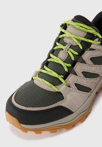 Lekkie buty trekkingowe z siateczkową i zamszową cholewką w ciemnozielonym i beżowym kolorze. Oferują jasnozielone sznurowadła oraz wytrzymałą podeszwę zapewniającą przyczepność.