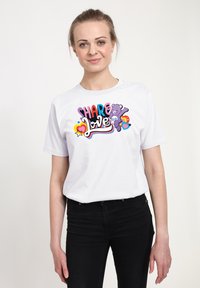 Vit bomull t-shirt med en färgglad grafik som säger "DELA Kärlek" med en tecknad björn och hjärtan som dekorationer. Kortärmad, rundad hals.