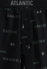 Czarne bawełniane bokserki z napisem "GAMING" i grafikami związanymi z podnoszeniem ciężarów w odcieniach zieleni i szarości. Posiadają prosty pasek w talii z metką "ATLANTIC".