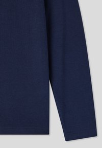 Camicia a maniche lunghe blu navy realizzata in tessuto morbido. Presenta un colletto rotondo e orli cuciti, con una texture liscia e uniforme su tutta la stoffa.