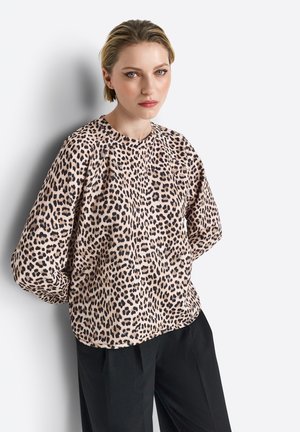 Leopard print blouse in soft fabric, featuring long sleeves and a rounded neckline, paired with black trousers against a neutral background.