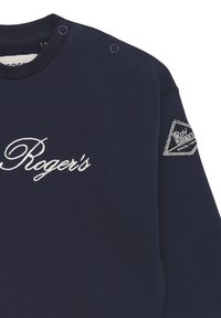 Felpa blu navy con scollatura rotonda, caratterizzata da testo ricamato "Roger's" e un'etichetta logo triangolare sulla manica. Dettagli con bottoni a pressione.