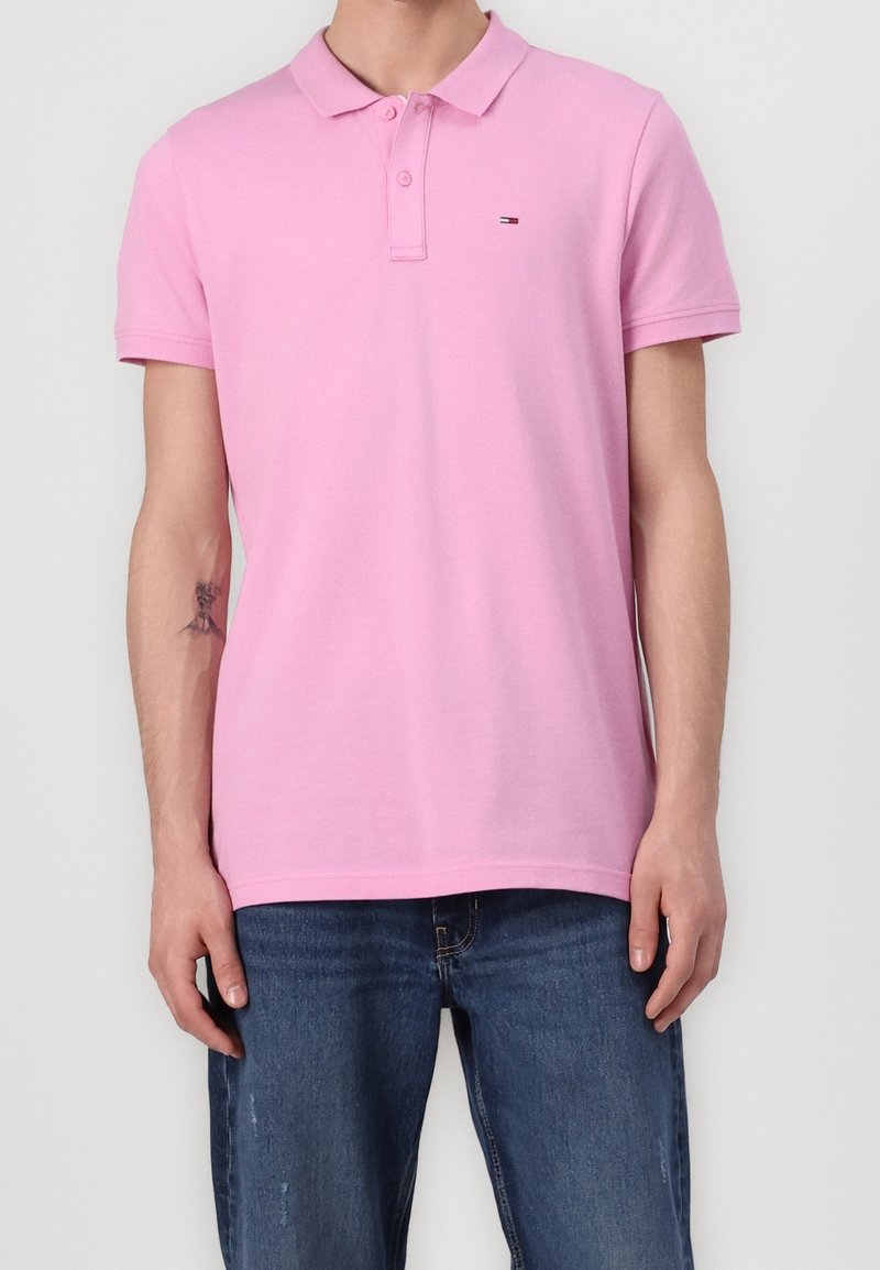 Polo shirt en coton rose avec un col classique, une patte de boutonnage à deux boutons, des manches courtes et un petit logo de marque sur la poitrine.
