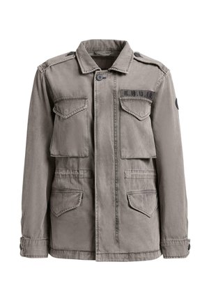 Pelēka militārā stila jaka ar pogām, četrām pārsegu kabatām un "K.H.U.J.O" uzplečņu uzlīmi kreisajā krūtīs.