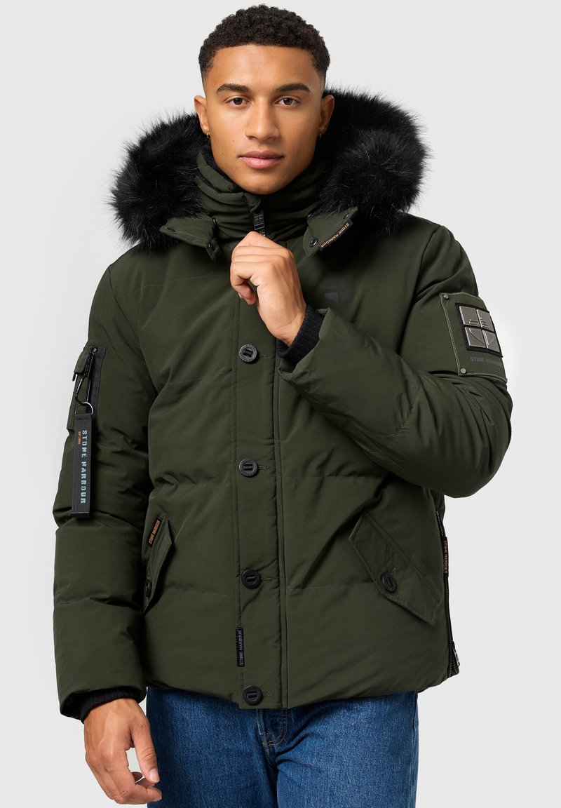 Giacca puffy verde oliva con cappuccio in pelliccia sintetica, bottoni neri, tasche laterali e tasca con zip sulla manica con dettagli del logo.