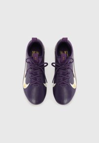Chaussures de football violettes en matériau synthétique texturé, avec des accents blancs et des lacets. Présente un patch logo et des détails cousus près du talon.