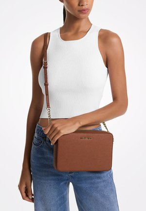 Brūns ādas crossbody soma ar taisnstūra formu, zelta detaļām un ķēdes siksnu, ar gludu tekstūru un zīmola logo priekšpusē.