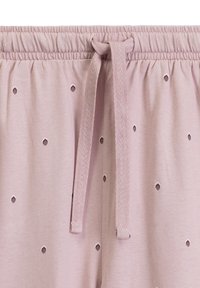Jasnoróżowe szorty piżamowe z elastycznym paskiem, ozdobione małymi diamentowymi wycięciami oraz gładką, miękką teksturą materiału.