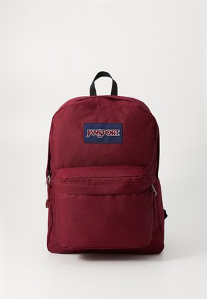 Sac à dos en tissu bordeaux avec une poche zippée à l'avant, des bretelles rembourrées et une poignée supérieure. Présente une étiquette de logo noir centrée à l'avant.