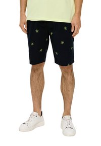 Marineblau Shorts aus Baumwolle mit grünem Blattstickerei, seitlichen Taschen und lockerer Passform. Kombiniert mit weißen Turnschuhen.
