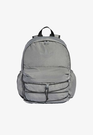 Sac à dos gris en matériau résistant à l'eau, avec une poche avant, des bretelles réglables et des détails en cordon élastique sur le devant.