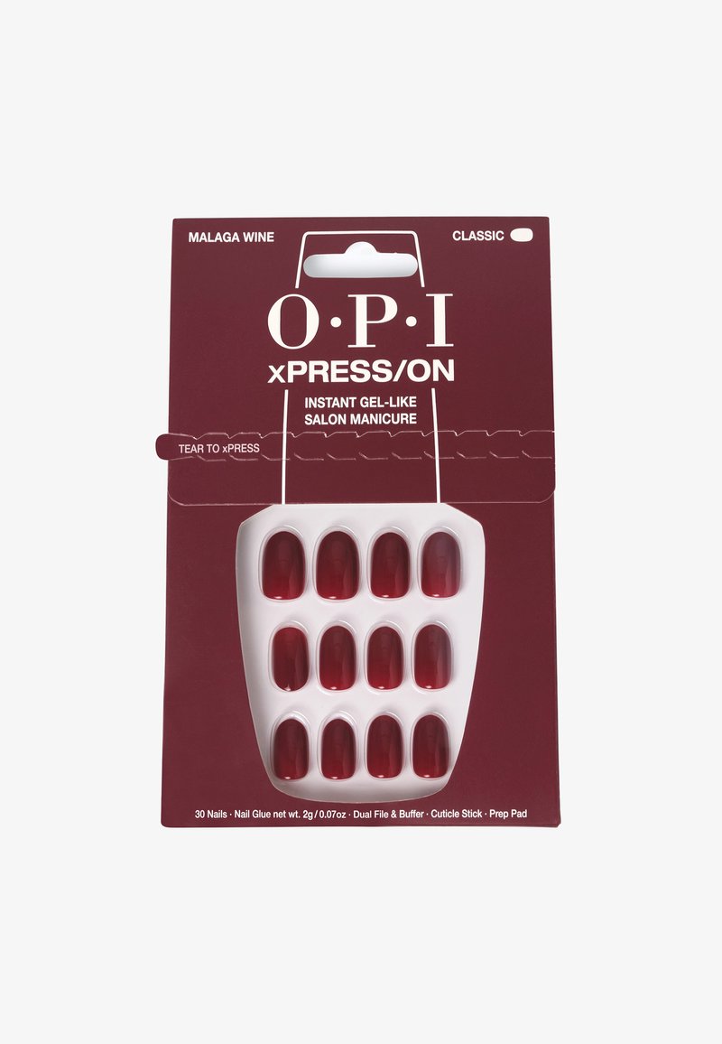 Des faux ongles rouges dans un plateau en plastique blanc, contenus dans un emballage bordeaux étiqueté "OPI xPRESS/ON." Inclus : colle pour ongles et outils de préparation.