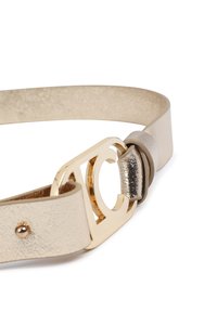 Cinturón de cuero dorado con una hebilla de metal de tono dorado brillante que presenta un diseño estilizado en forma de "C", y una trabilla ajustable.