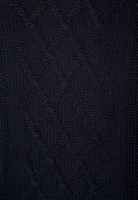 Dunkelblaues, gestricktes Textil mit einem auffälligen Kabelmuster, das strukturierte Maschen und eine glatte Oberfläche aufweist.