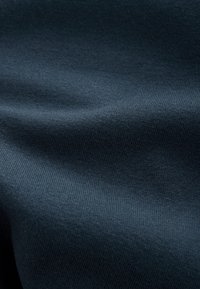 Dark blue fabric displaying a smooth, textured surface with a fine ribbed pattern and subtle sheen. Flexible and drapes gently.