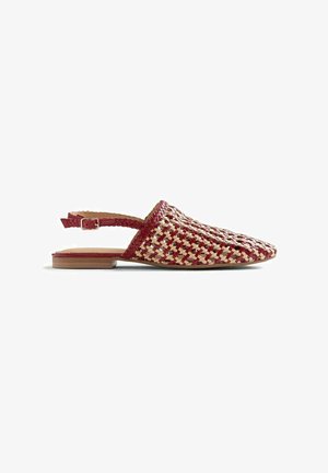 Mule da donna piatta con cinturini intrecciati rossi e beige, punta chiusa e appuntita, e cinturino posteriore regolabile con fibbia.